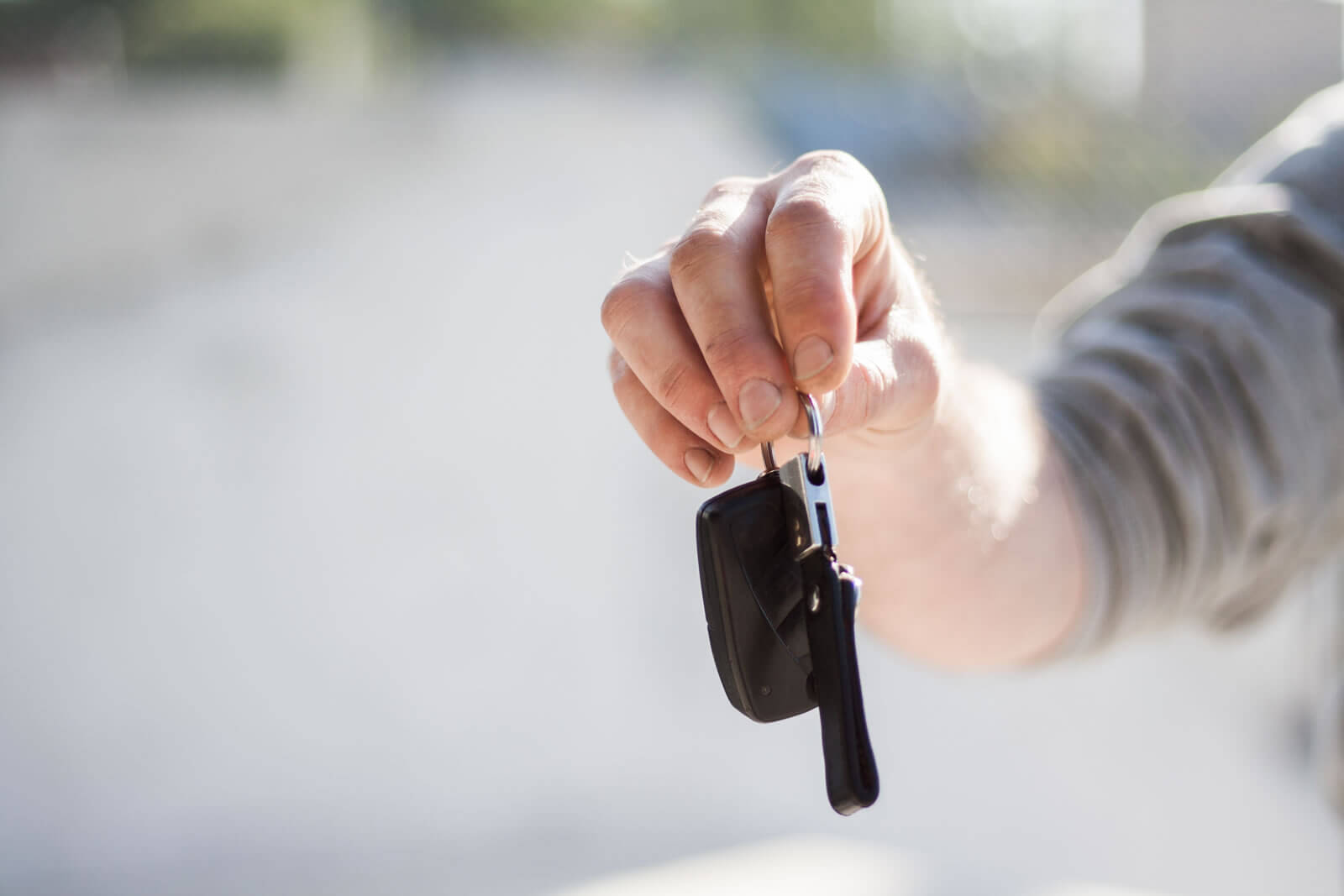 A man holding a key chain with car keys