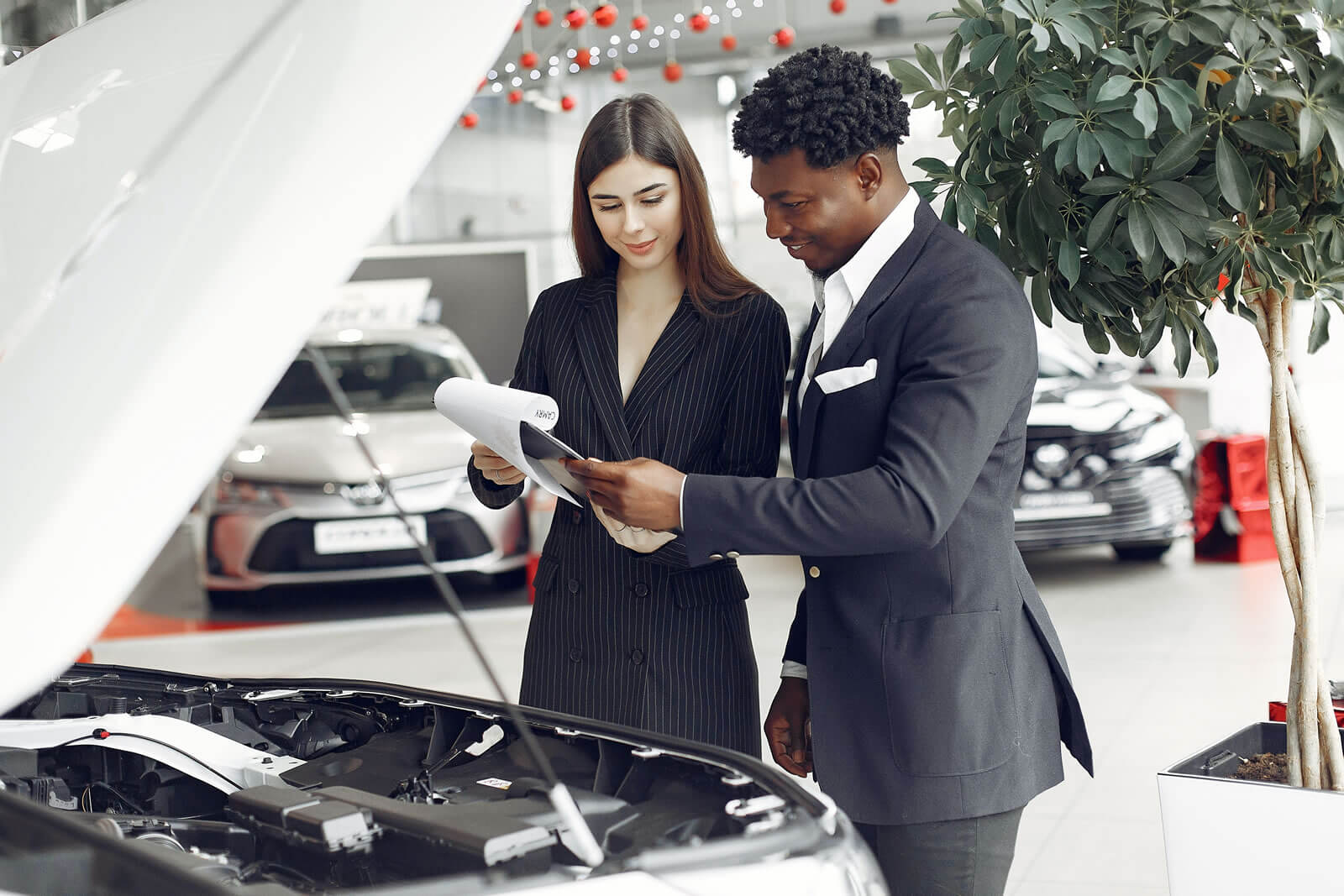 A car salesman reading documents with a consumer